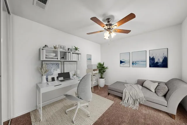 a living room with furniture and a ceiling fan