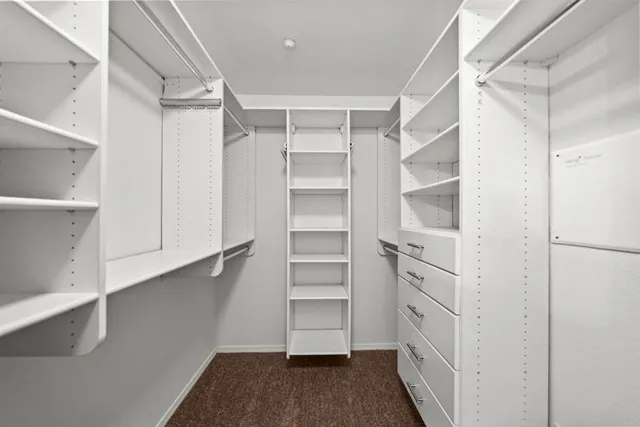 a view of walk in closet with empty racks