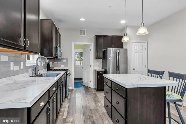 a kitchen with stainless steel appliances granite countertop a sink a stove and a refrigerator