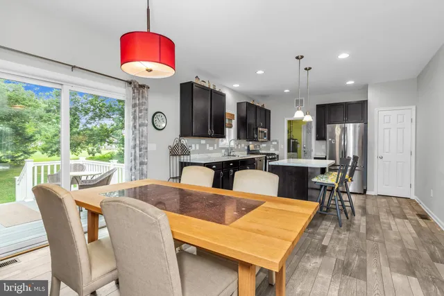a view of a dining room with furniture a chandelier and wooden floor