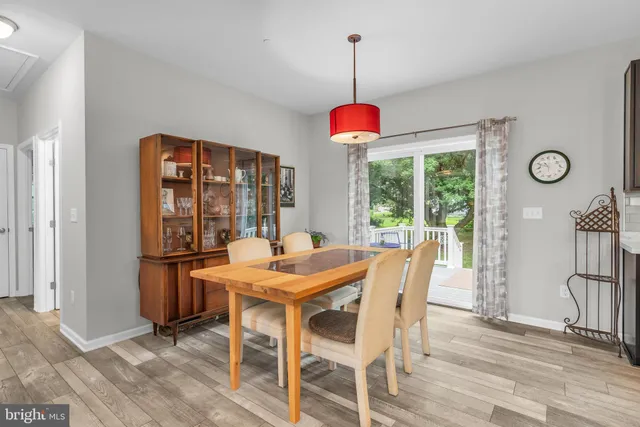 a dining room with furniture window and wooden floor
