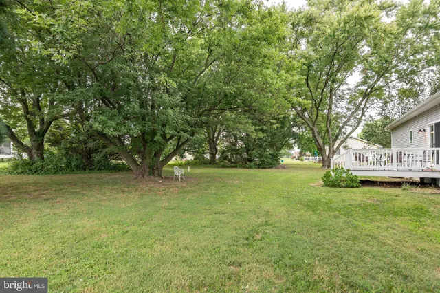 a view of a house with a big yard and large trees