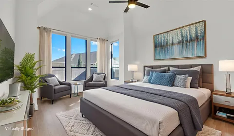 a bedroom with a bed a couch and a large window