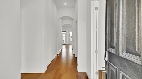 a view of a hallway with wooden floor