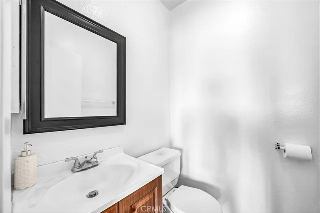 a bathroom with a sink vanity mirror and toilet
