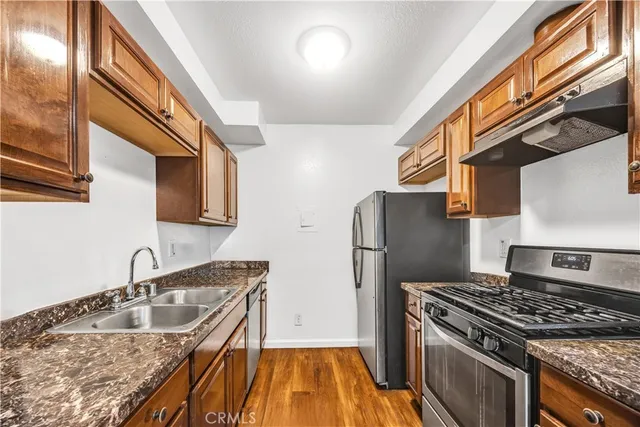 a kitchen with stainless steel appliances granite countertop a sink stove and refrigerator
