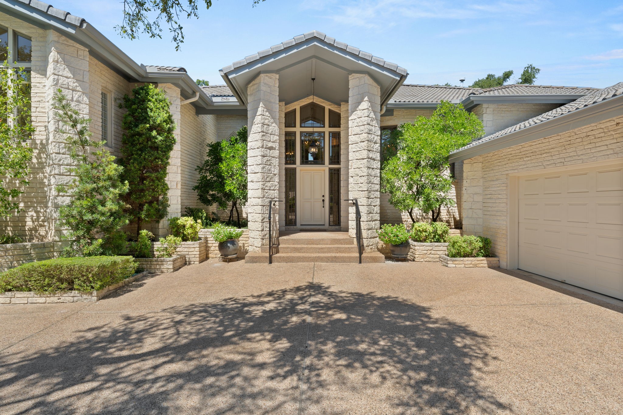 Regal home of white Austin stone has oversized 2 car garage with golf cart garage and air-conditioned workshop. New beautiful epoxy garage floor