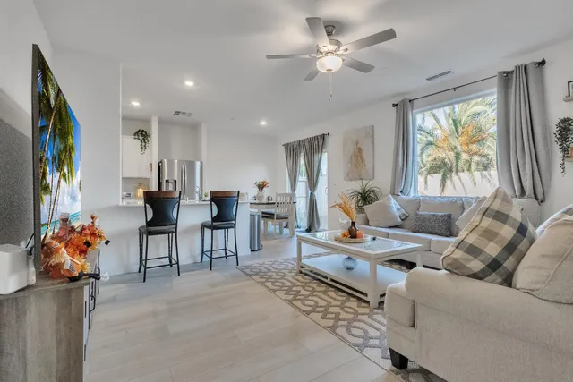 a living room with furniture a chandelier and a flat screen tv