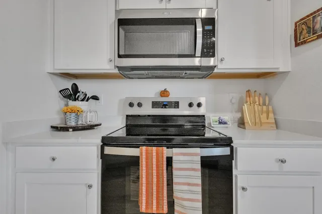 a kitchen with stainless steel appliances granite countertop a refrigerator and a stove top oven