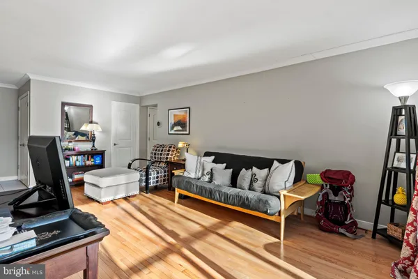 a living room with furniture a flat screen tv and a table