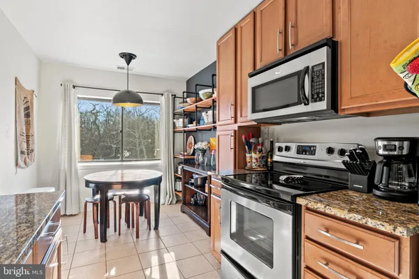 a kitchen with stainless steel appliances granite countertop a stove and a microwave