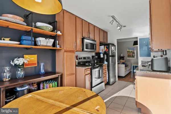a kitchen with stainless steel appliances granite countertop a stove refrigerator and a microwave