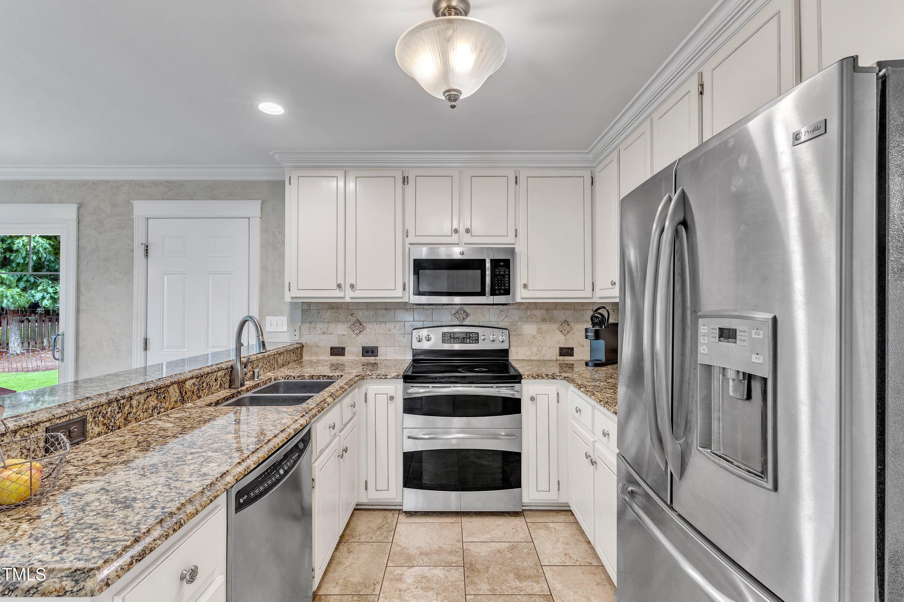 2721 Dahlgreen Road Raleigh, NC 27615 - Photo 16 of 59 a kitchen with granite countertop a refrigerator stove and sink