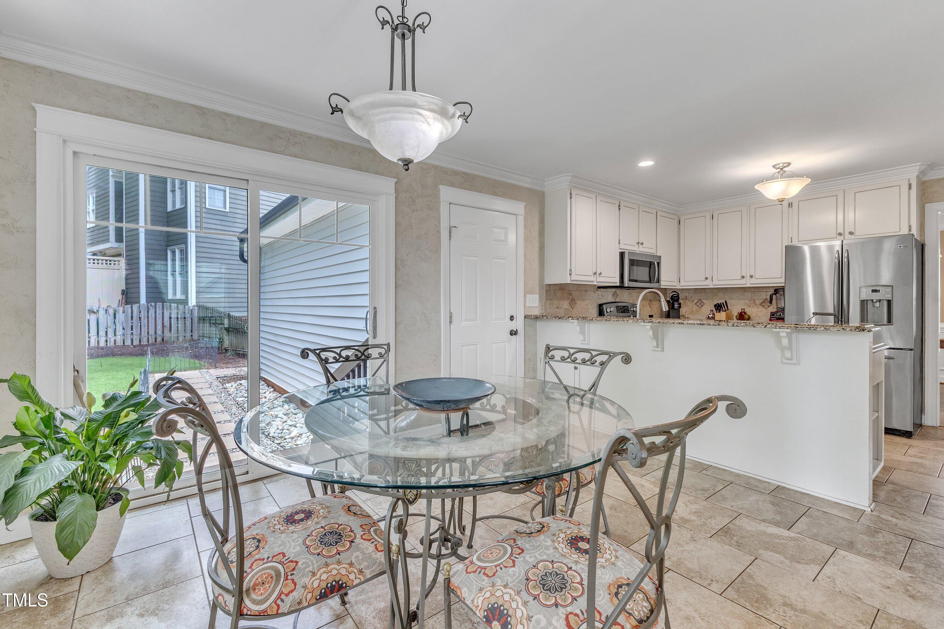 2721 Dahlgreen Road Raleigh, NC 27615 - Photo 23 of 59 a kitchen with stainless steel appliances granite countertop a dining table chairs and white cabinets