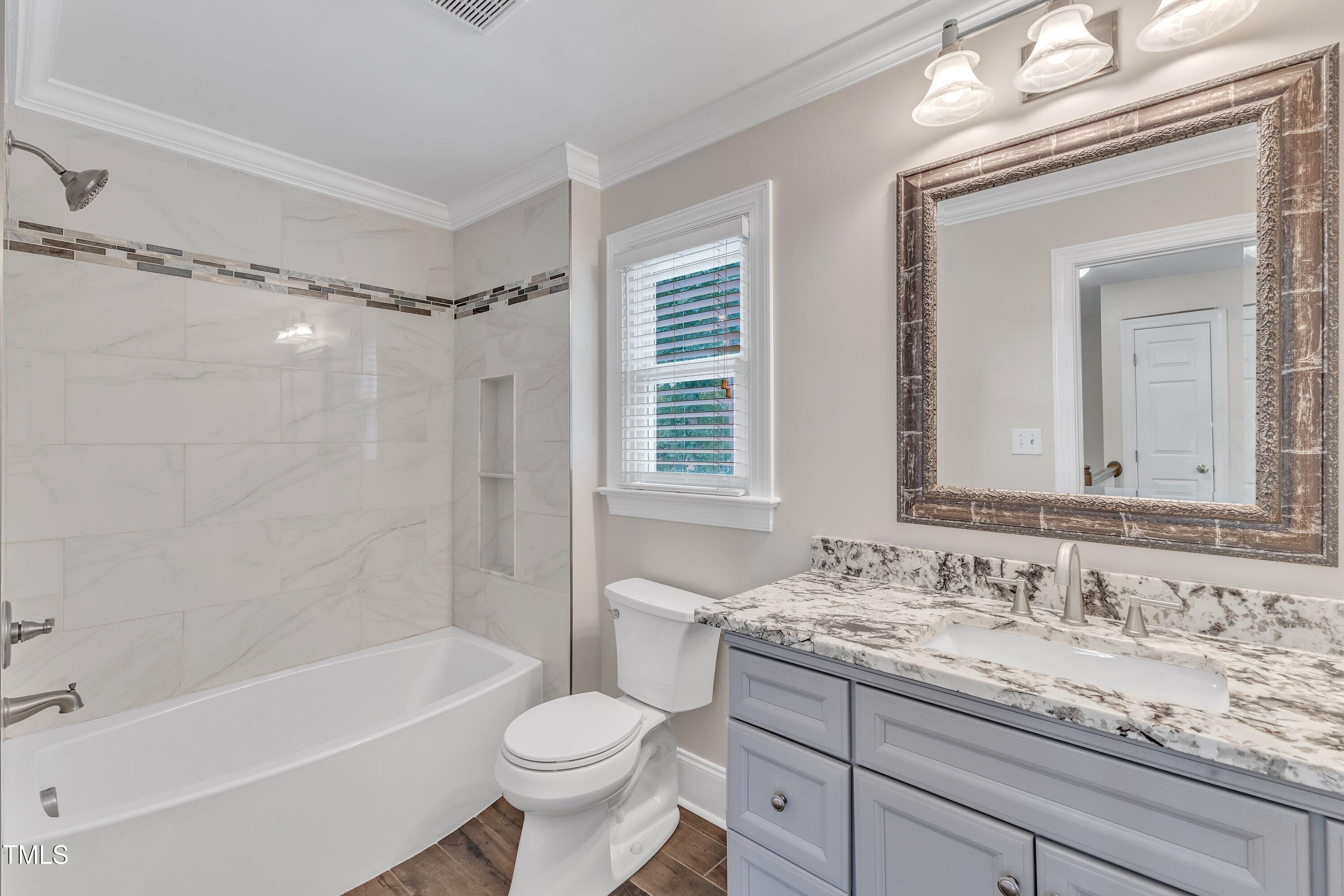 2721 Dahlgreen Road Raleigh, NC 27615 - Photo 40 of 59 a bathroom with a granite countertop sink toilet mirror and bathtub