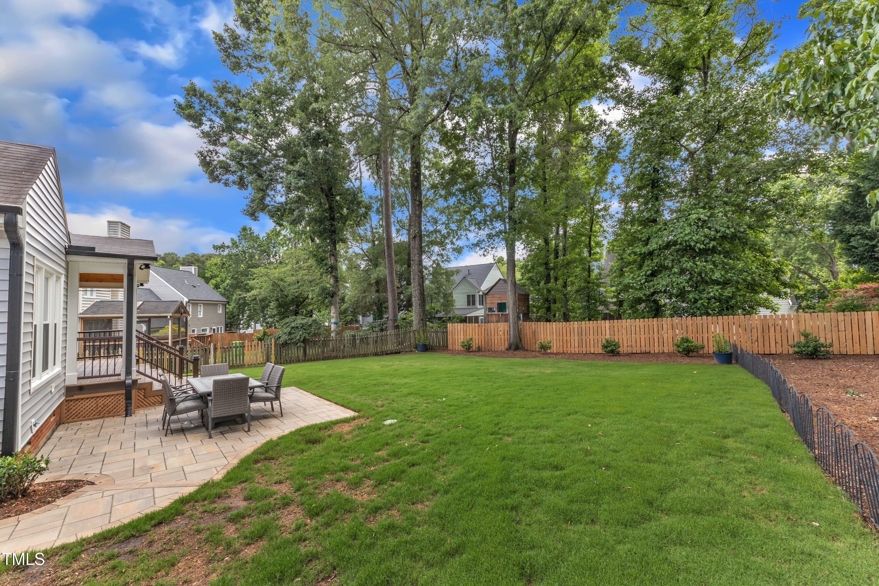 2721 Dahlgreen Road Raleigh, NC 27615 - Photo 47 of 59 a view of a backyard with table and chairs a fire pit and a large tree