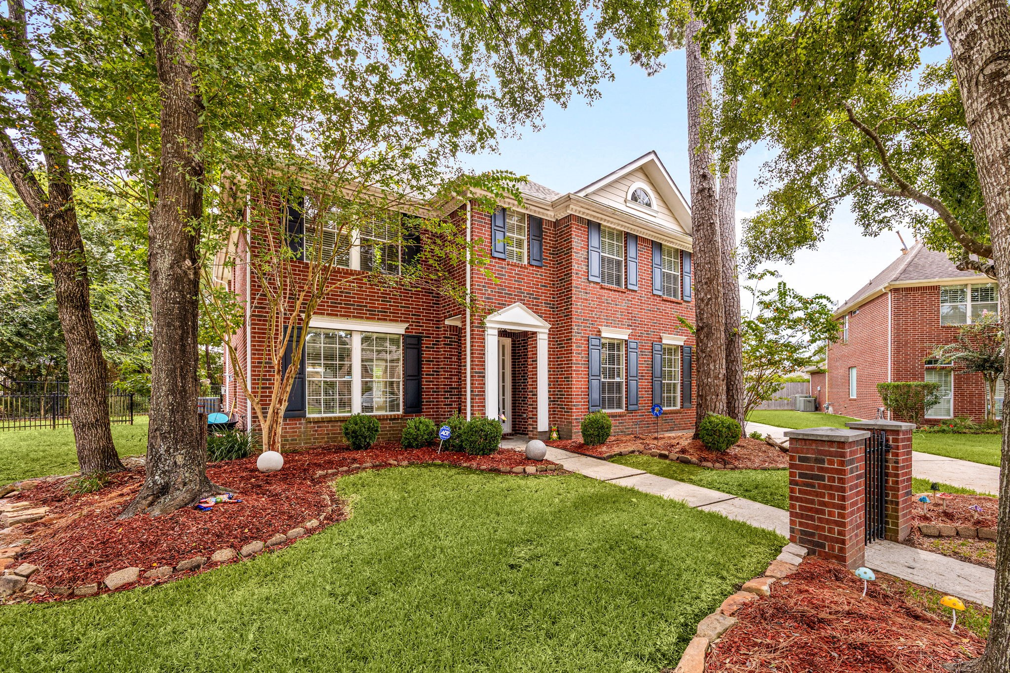 Welcoming front exterior surrounded by mature landscaping and a beautifully maintained lawn.