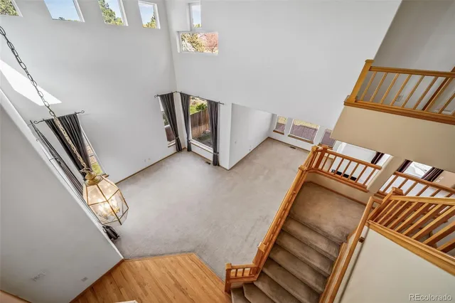 a view of an empty room with wooden floor and stairs