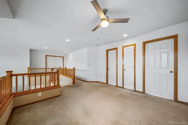 an empty room with windows & fan