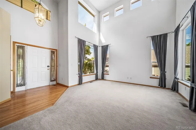 a view of a room with large windows and stairs