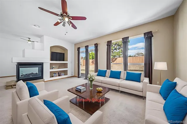 a living room with furniture fireplace and a large window