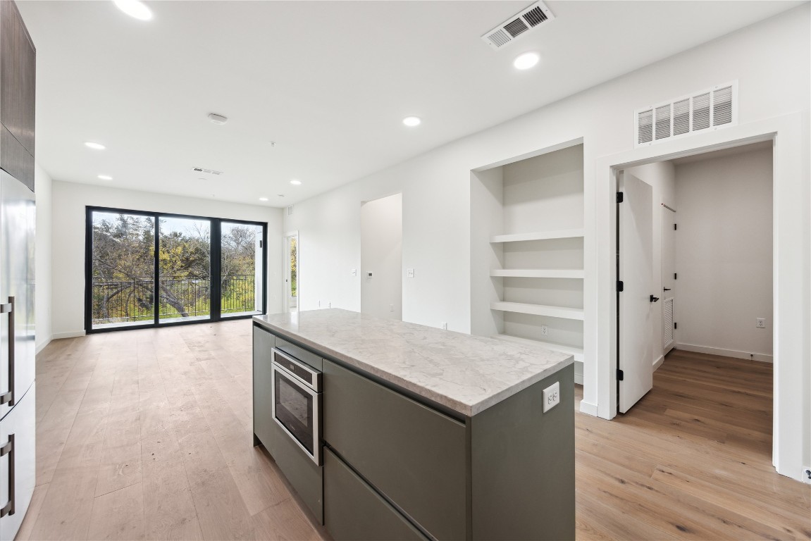2209 South 1st Street, Unit 226 Austin, TX 78704 - Photo 3 of 27 a kitchen with a wooden floor and window