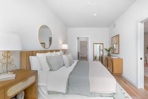 a bedroom with a bed and wooden floor