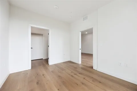 an empty room with wooden floor & closet