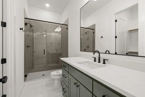a bathroom with a shower sink vanity granite and shower
