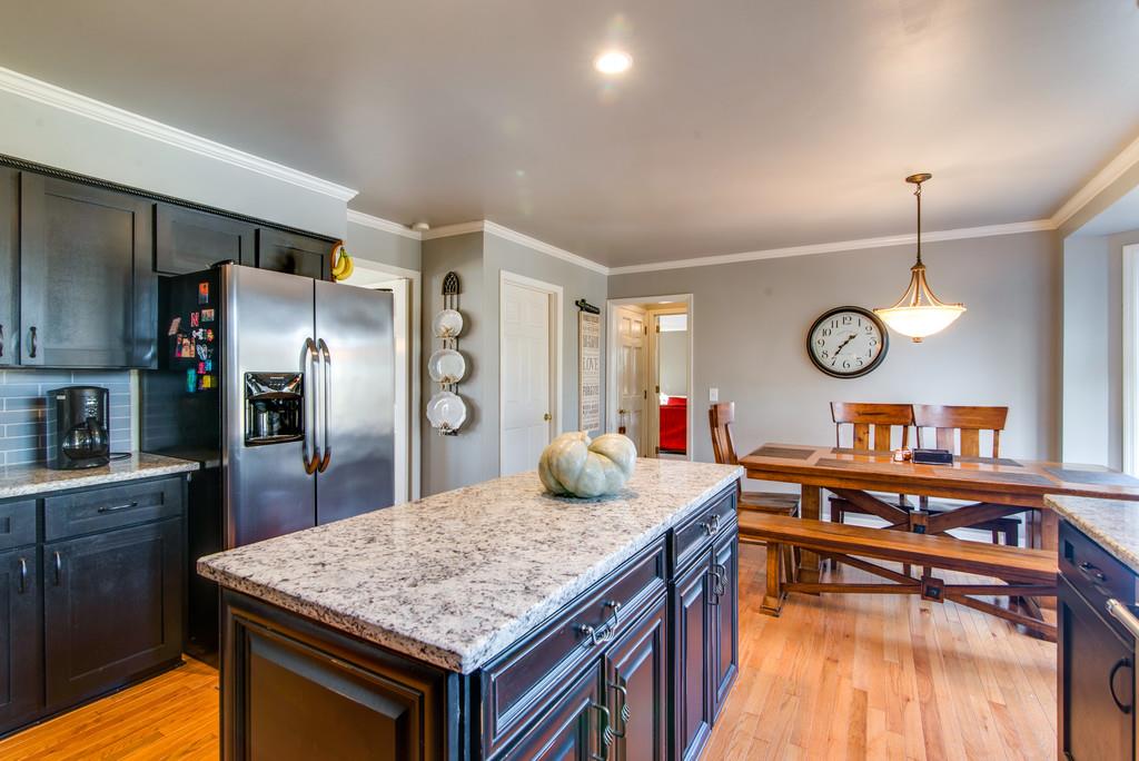 113 Shiloh Ridge Hendersonville, TN 37075 - Photo 13 of 30 a kitchen with stainless steel appliances granite countertop a table chairs a stove and a refrigerator