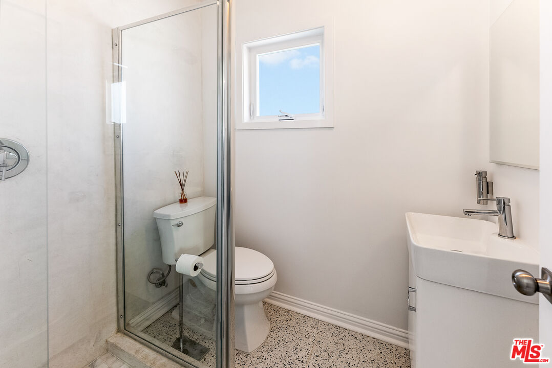 1253 South Rimpau Boulevard Los Angeles, CA 90019 - Photo 29 of 71 a bathroom with a sink a toilet and a mirror