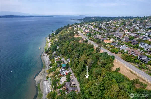 an aerial view of a house with a yard lake and mountain view in back