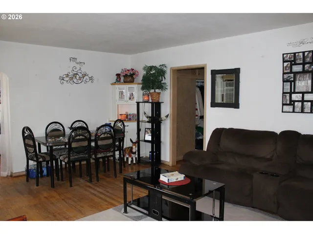 a living room with furniture a dining table and paintings on the wall