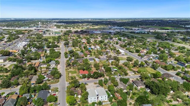 an aerial view of residential houses with outdoor space and trees
