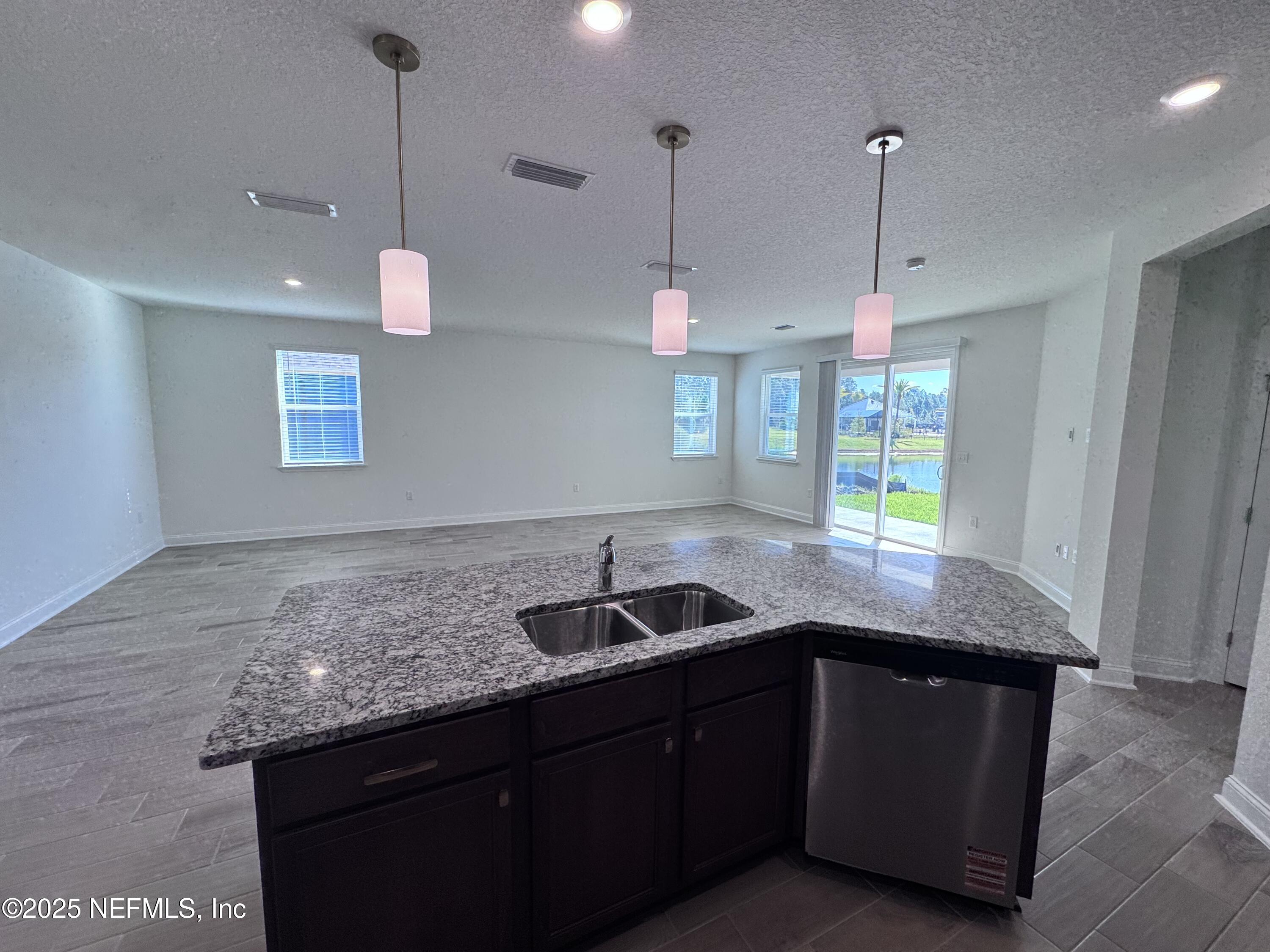 11156 Spg Mdws Road Jacksonville, FL 32222 - Photo 11 of 33 a kitchen with granite countertop kitchen island a sink and a wooden floor