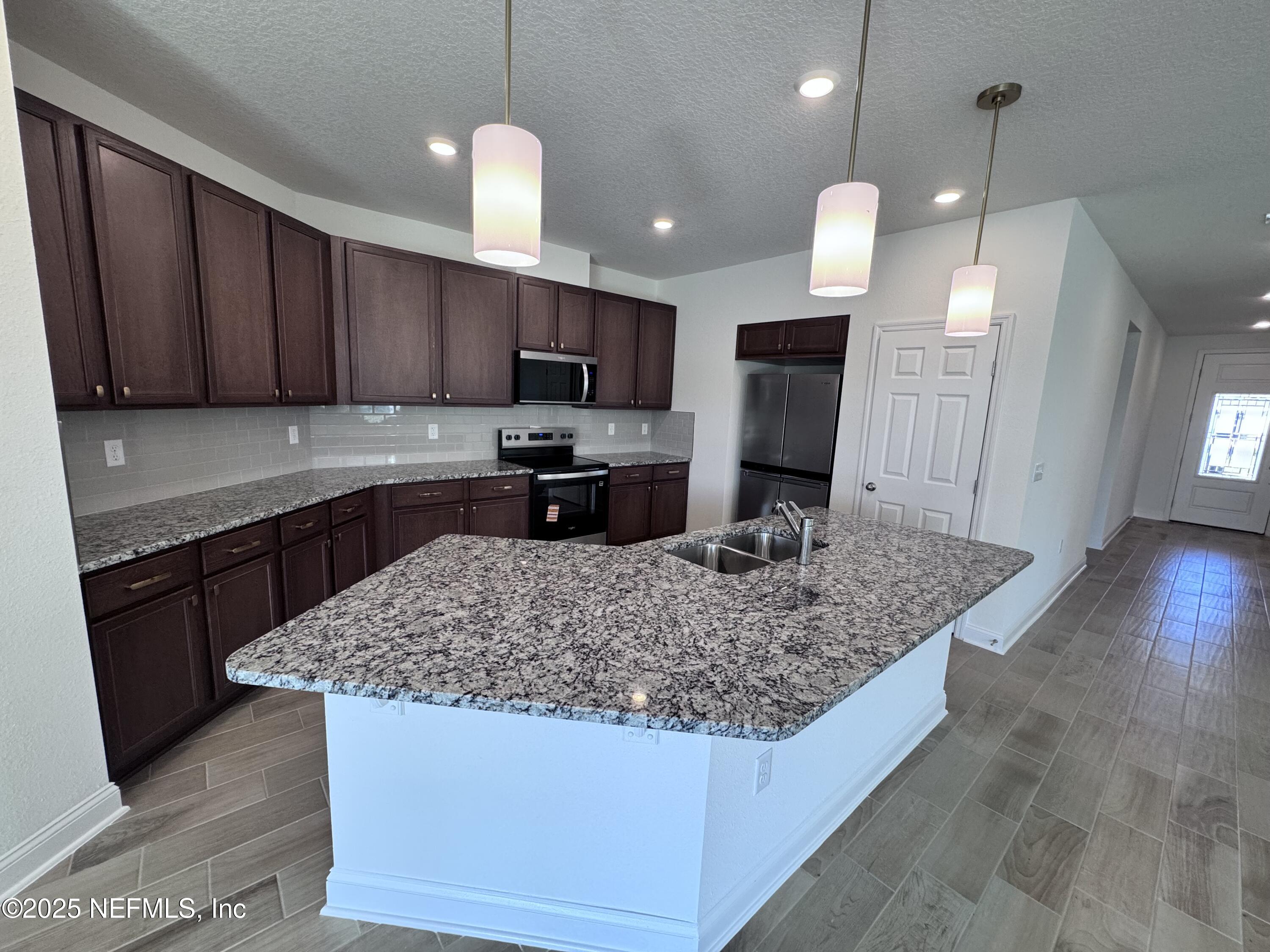 11156 Spg Mdws Road Jacksonville, FL 32222 - Photo 12 of 33 a kitchen with kitchen island granite countertop a sink a counter top space appliances and cabinets