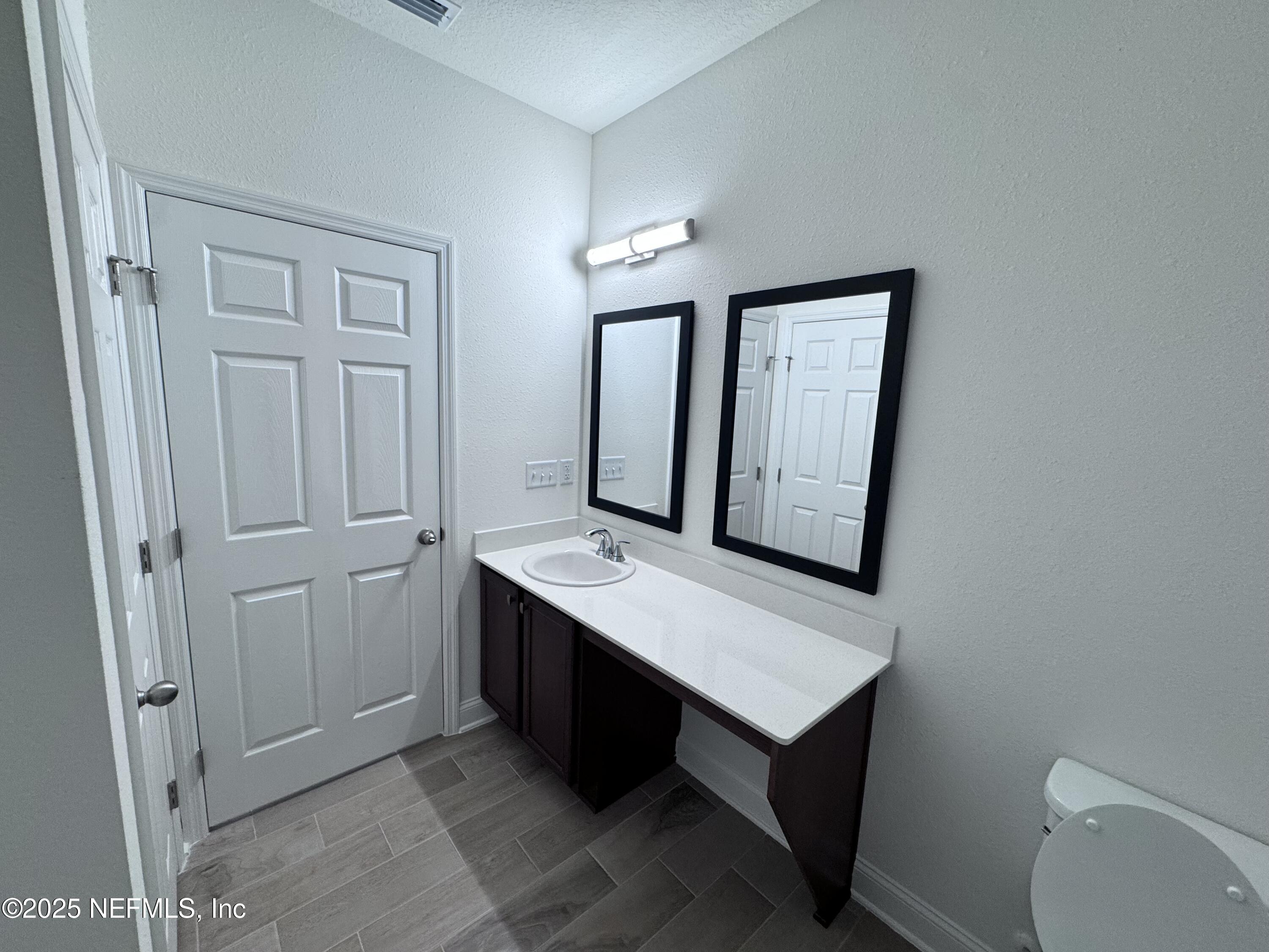 11156 Spg Mdws Road Jacksonville, FL 32222 - Photo 23 of 33 a room with a sink mirror and a toilet