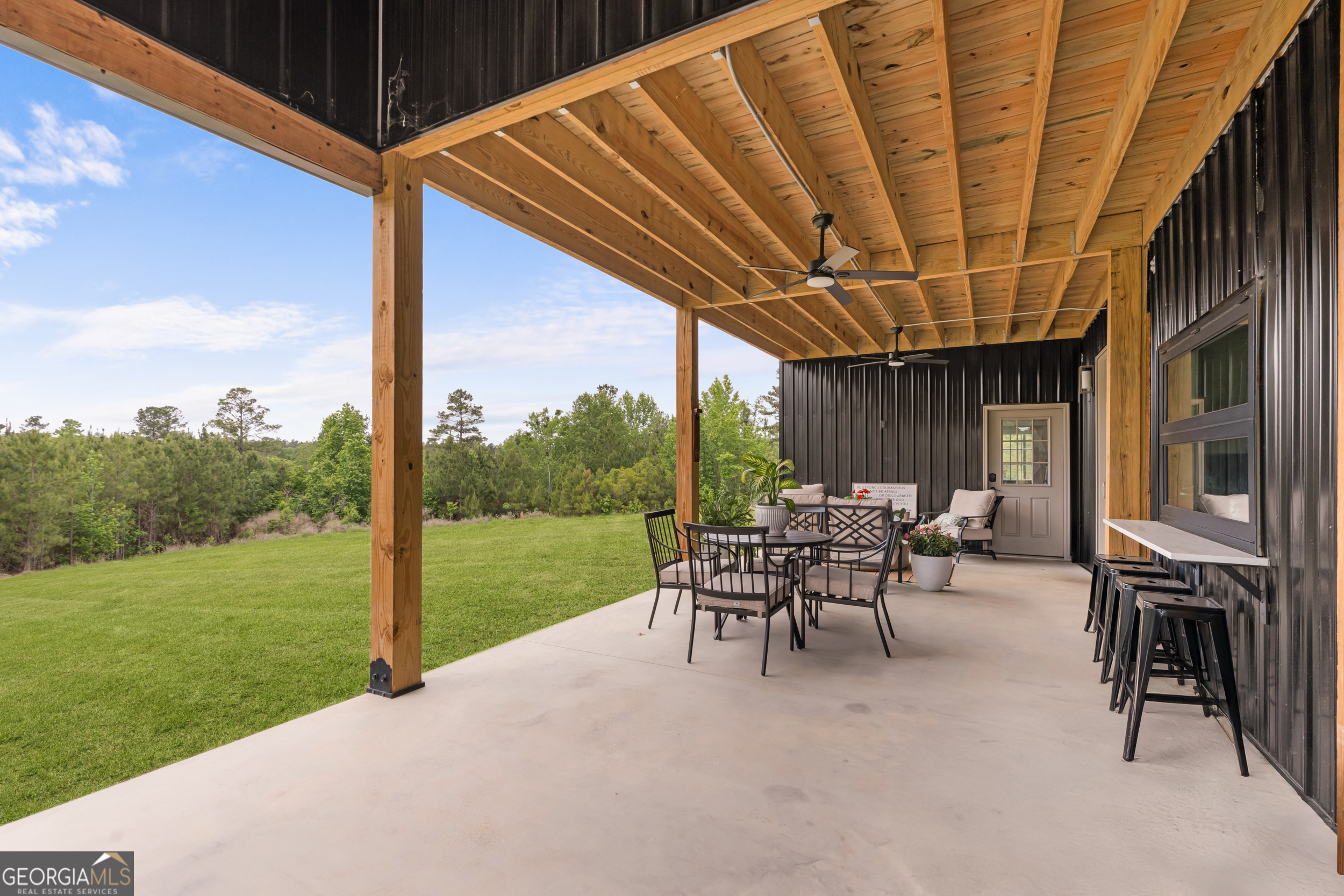 2973 Buttermilk Road Sylvania, GA 30467 - Photo 36 of 48 a view of a patio with table and chairs under an umbrella with a big yard