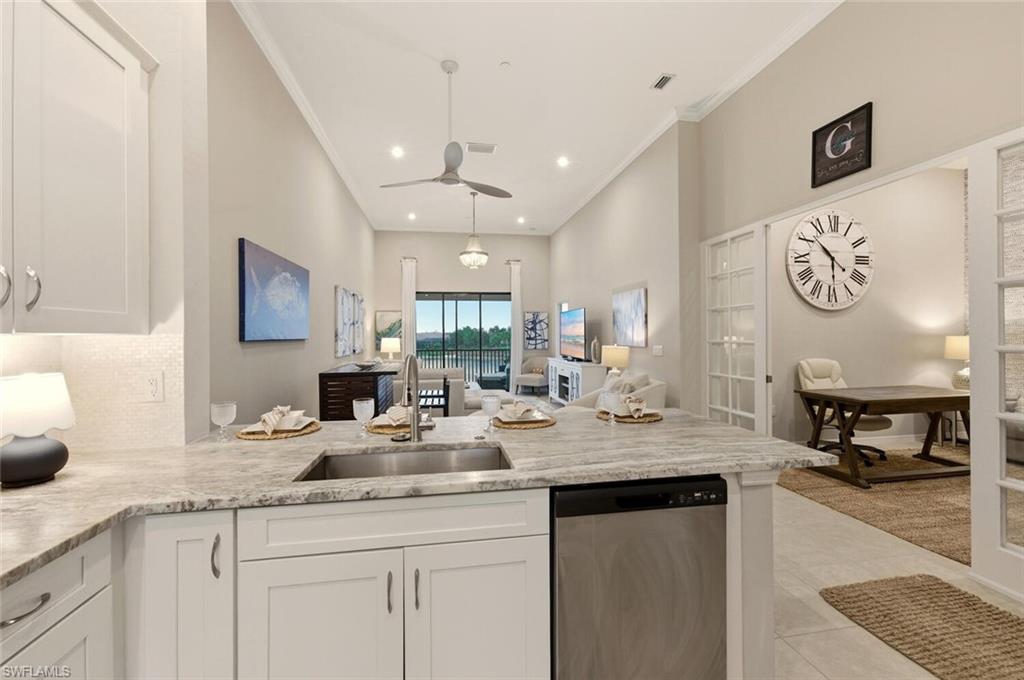 9365 Pocida Court, Unit 202 Naples, FL 34119 - Photo 16 of 40 a kitchen with a sink dishwasher a dining table and chairs with wooden floor
