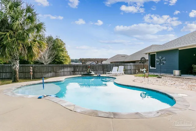 a view of a backyard with swimming pool