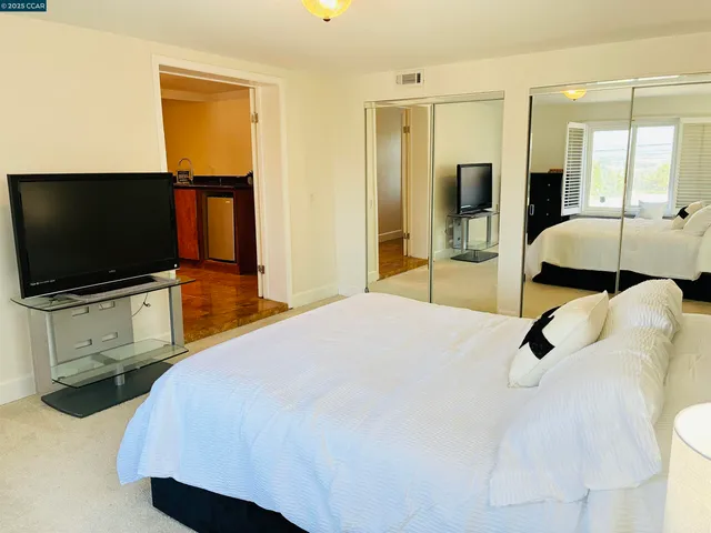 a bedroom with a bed and a flat screen tv