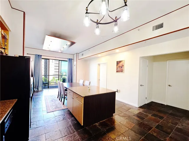 a large kitchen with a table and refrigerator