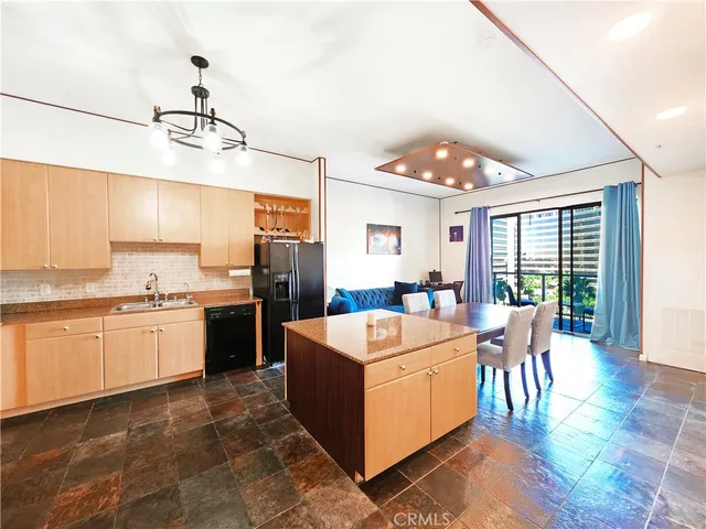 a living room with stainless steel appliances granite countertop furniture and a kitchen view