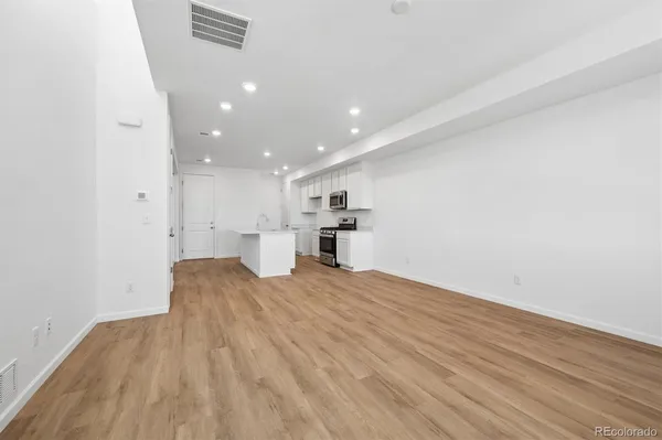 a view of empty room with wooden floor
