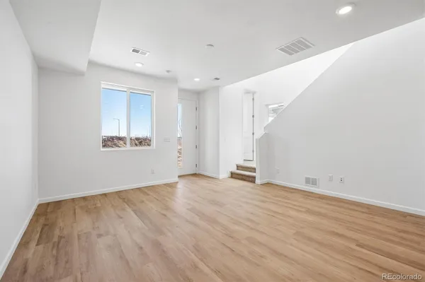 a view of an empty room with wooden floor