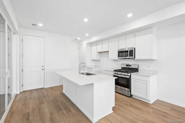 a kitchen with stainless steel appliances a sink stove and cabinets