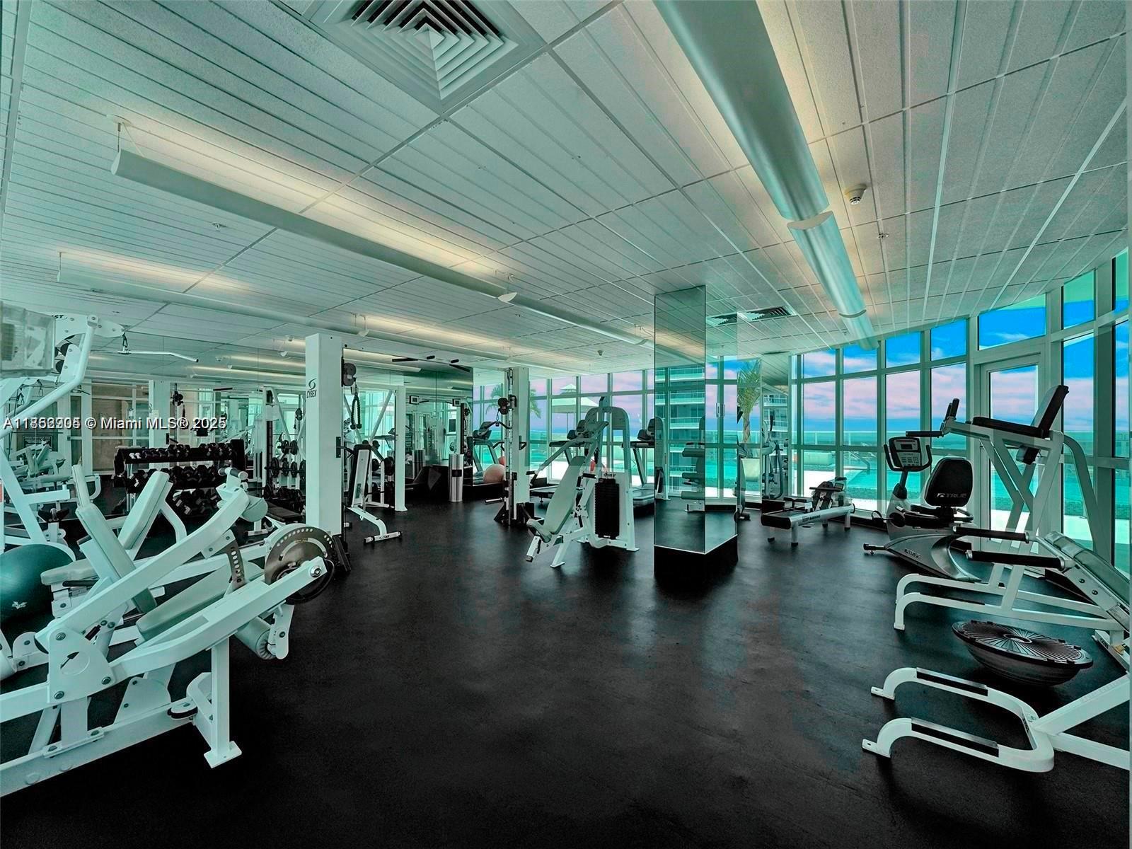 218 Southeast 14th Street, Unit 1407 Miami, FL 33131 - Photo 4 of 7 a gym with lots of furniture and potted plants