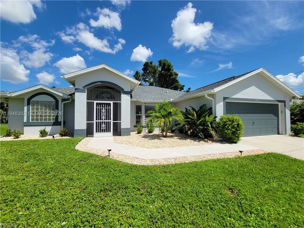 237 Southwest 47th Street Cape Coral, FL 33914 - Photo 1 of 50 a front view of a house with a garden