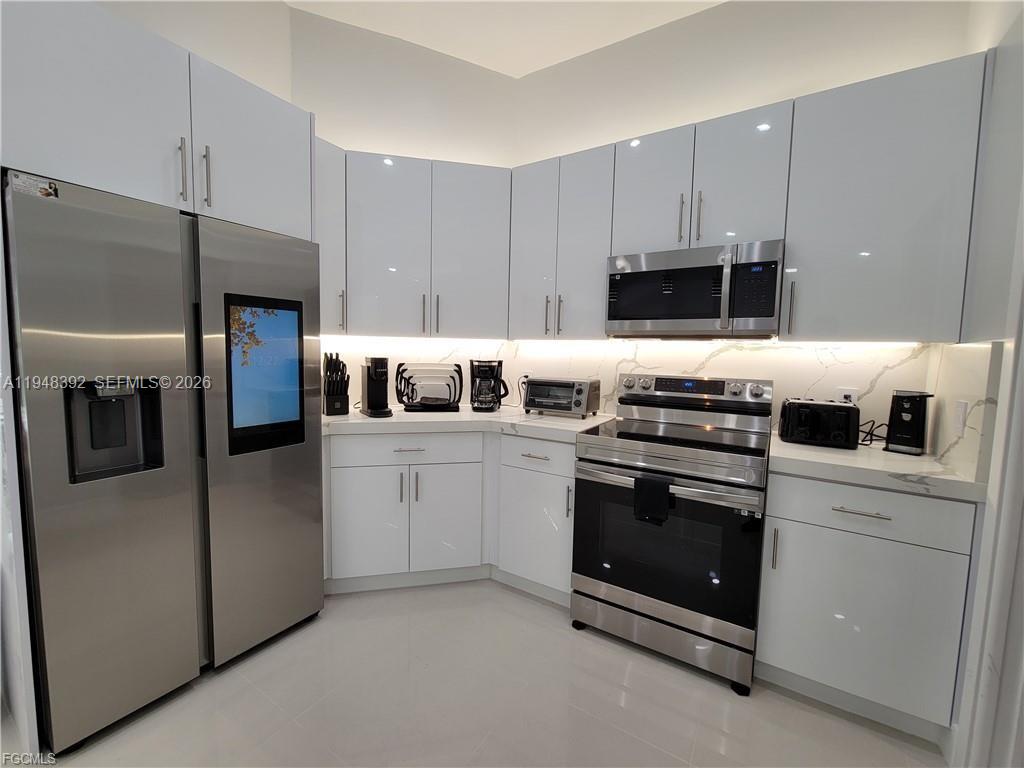 237 Southwest 47th Street Cape Coral, FL 33914 - Photo 10 of 50 a kitchen with a stove and a refrigerator