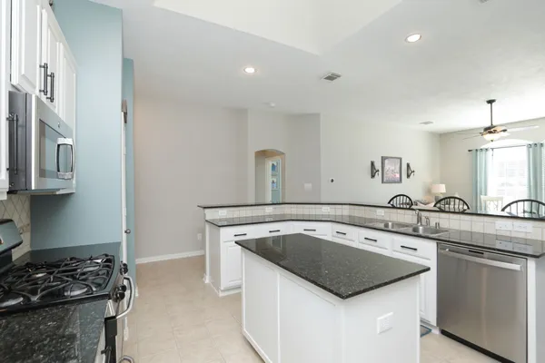 a kitchen with granite countertop a sink and a stove top oven